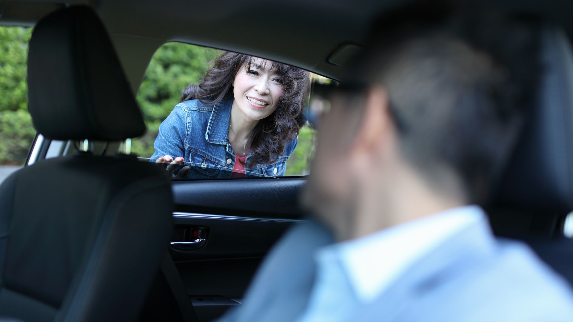 A woman sitting in the back seat of a car