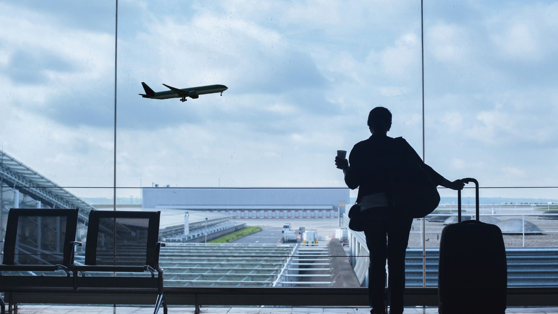 A person standing in front of an airport window