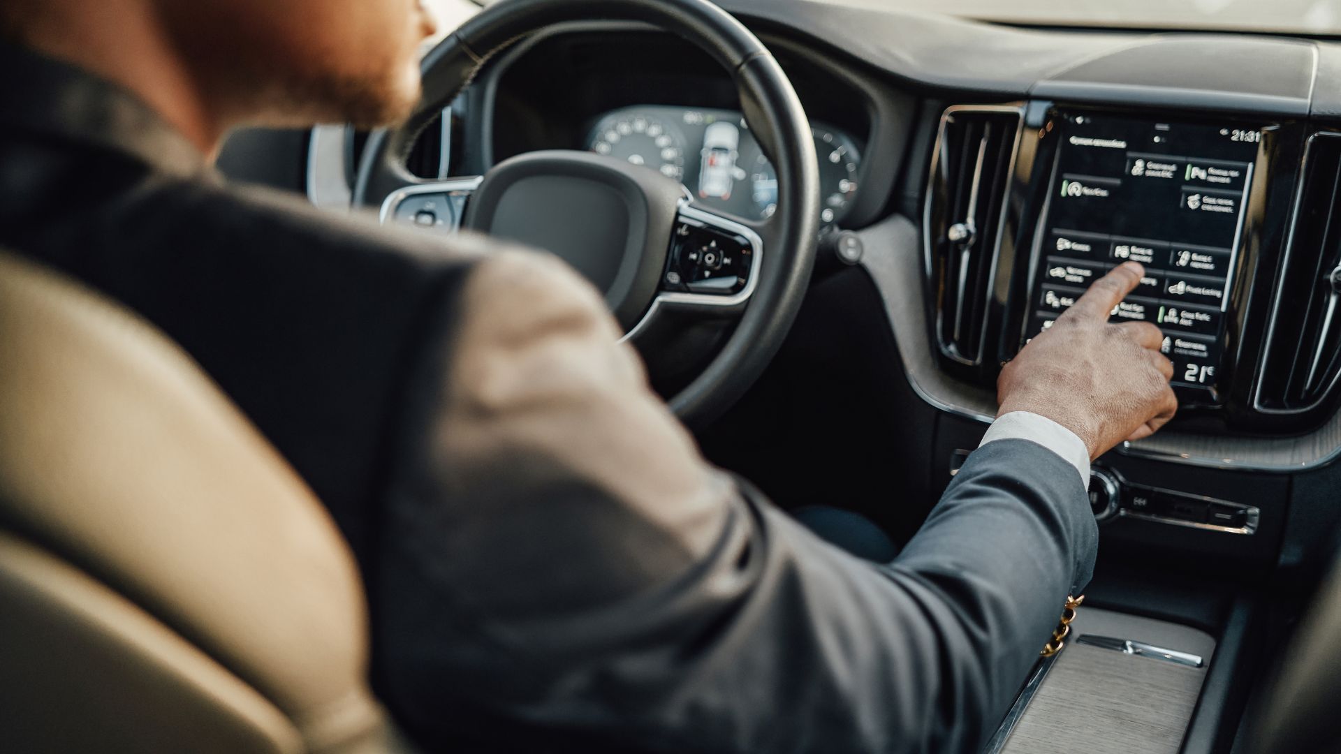 A man in a suit driving a car
